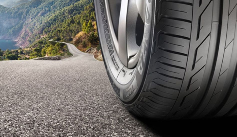 foto de um pneu em uma estrada em meio a montanhas